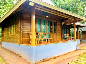 a small wooden cabin with tables and chairs at Royal Wooden villa in Mananthavady