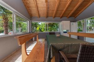 a dining room with a table and chairs and windows at Apartments Sorić in Trogir