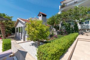 uma casa com um jardim em frente em Apartments Sorić em Trogir