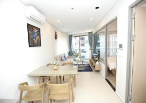 a living room with a table and chairs in a room at The Song QA Apartment in Vung Tau