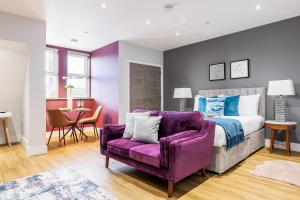 a bedroom with a bed and a purple couch at Tower House Apartments in Bournemouth
