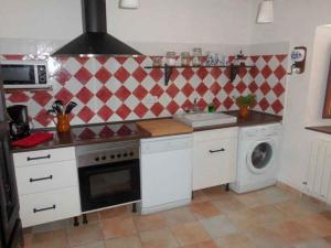 a kitchen with a stove and a washing machine at Casa El Barriejo en Campo de San Pedro 8 pax 