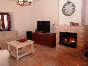 a living room with a fireplace and a clock on the wall at Casa El Barriejo en Campo de San Pedro 8 pax 