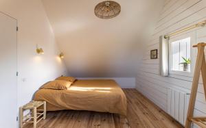 Schlafzimmer mit einem Bett und einem Fenster in der Unterkunft Gîtes de Lézinadou - 8 personnes - Plomeur La Torche in Plomeur