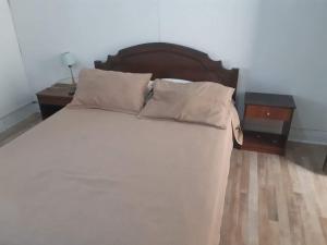 ein Schlafzimmer mit einem großen weißen Bett mit zwei Nachttischen in der Unterkunft Hostal Herencia Porteña in Valparaíso
