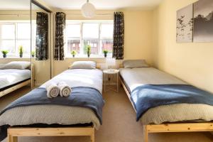 a bedroom with two beds and a mirror at Guildford Townhouse with Parking in Guildford