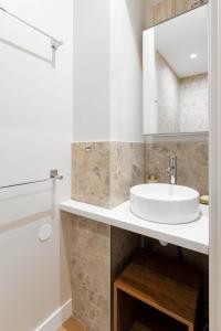 a white bathroom with a sink and a shower at Appart Hôtel Coraline - Genas Lyon Eurexpo in Genas