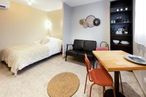 ジュナにあるAppart Hôtel Coraline - Genas Lyon Eurexpoのベッドルーム1室(ベッド1台、テーブル、椅子付)