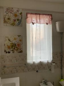 a bathroom with a sink and a window with flowers at Sotto le stelle di Capua in Capua