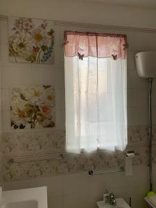 a bathroom with a sink and a window with flowers at Sotto le stelle di Capua in Capua +26 photos
