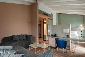 a living room with a couch and a table at HT Hotel Trieste in Gradisca dʼIsonzo