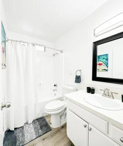 Baño blanco con aseo y lavamanos en Dual-Level Delight 2BR in Hollywood - BR4-BH en Los Ángeles