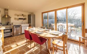 a kitchen and dining room with a table and chairs at Gîtes de Lézinadou - 8 personnes - Plomeur La Torche in Plomeur