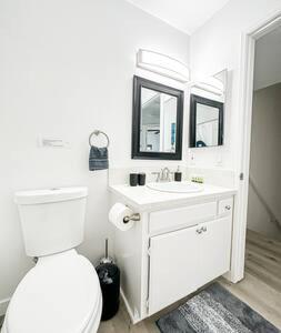 Baño blanco con aseo y lavamanos en Dual-Level Delight 2BR in Hollywood - BR4-BH en Los Ángeles