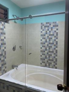 uma casa de banho com uma banheira e um chuveiro em vidro. em La Rosa Buga em Guadalajara de Buga