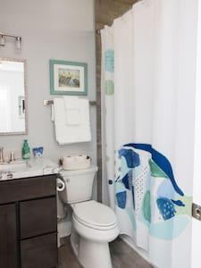 a bathroom with a toilet and a shower curtain at Fins Up in Long Beach +11 photos