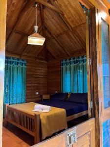 a bedroom with a bed in a room with blue curtains at Royal Wooden villa in Mananthavady