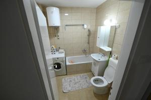 a bathroom with a toilet and a tub and a sink at Apartman N&D in Banja Luka