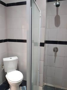 a bathroom with a toilet and a glass shower at La Résidence in Lomé