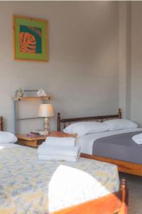 サリナスにあるHostel Casa Betancourtのベッドルーム1室(ベッド2台、ランプ付きテーブル付)