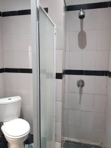 uma casa de banho com um WC e uma cabina de duche em vidro. em La Résidence em Lomé