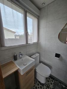 a bathroom with a toilet and a sink and a window at Chambre indépendante, privée climatisée avec parking in Montauban