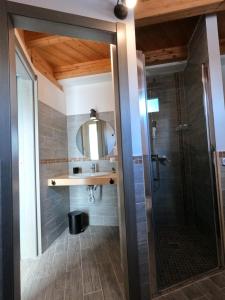 uma casa de banho com um chuveiro e um espelho. em Green Guest House em Oristano