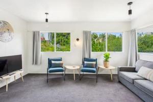 een woonkamer met een bank en een tafel en stoelen bij Cockle Bay Getaway is close to beach in Auckland