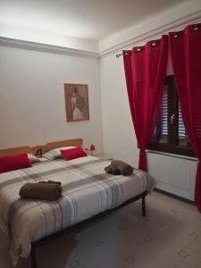 una camera da letto con un grande letto con tende rosse di Le Sorgenti Guest House a Ilbono