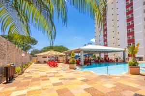 a pool at a hotel with a palm tree at Villas DiRoma Residence - HUP CALDAS NOVAS in Caldas Novas