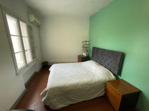 um quarto com uma cama branca e 2 janelas em Casa Blanca em Santiago