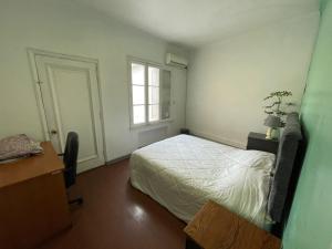 1 dormitorio con cama blanca y ventana en Casa Blanca, en Santiago