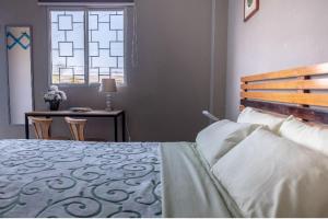 1 dormitorio con cama, escritorio y ventana en Hostel Casa Betancourt, en Salinas