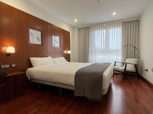 Habitación de hotel con cama grande y ventana en Hotel Gran Regente, en Oviedo