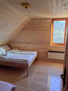 um quarto com uma cama num quarto de madeira em Vikendica Nina 2 em Zlatibor