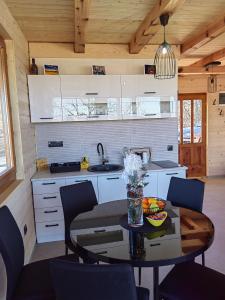 a kitchen with a table and chairs in a cabin at Vikendica Nina 2 in Zlatibor