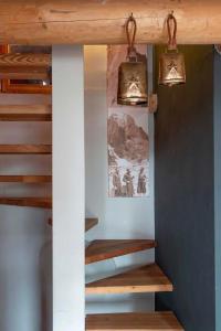 een trap in een kamer met twee lichten aan de muur bij La Stalla in Vicosoprano