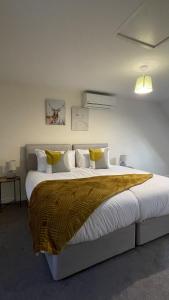 una camera da letto con un grande letto con cuscini gialli e bianchi di Spacious 4 bedroom, perfect for contractors, families, private parking a Wootton Bassett