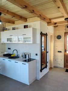 uma cozinha com armários brancos e um lavatório em Vikendica Nina 2 em Zlatibor