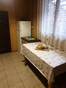 a kitchen with a table and a white refrigerator at Casa Lacramioara in Sîmbăta de Sus