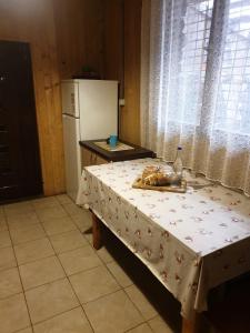 a kitchen with a table and a white refrigerator at Casa Lacramioara in Sîmbăta de Sus +31 photos