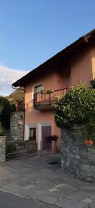 Casa con balcón y pared de piedra en Il Pesco en Nus