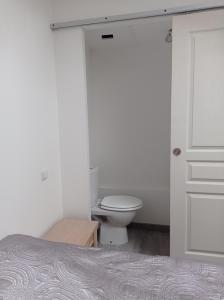 uma casa de banho branca com um WC e uma porta em Résidence naturiste Eden 117 em Leucate