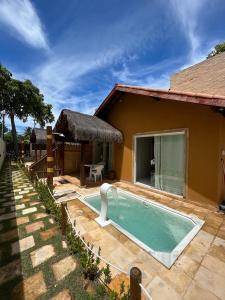 a swimming pool in front of a house at Maragogi Chalés Antunes in Maragogi