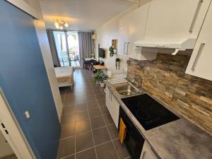 a kitchen with a sink and a stove top oven at Brise Marine - Saint Gilles les Bains - Boucan - Studio vue mer in Saint-Gilles les Bains