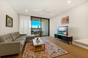 a living room with a couch and a tv at Excellent location Luxury 2BR apt w carpark in Brisbane