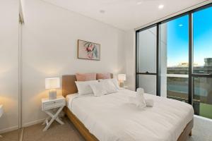 a bedroom with a large bed with a large window at Excellent location Luxury 2BR apt w carpark in Brisbane