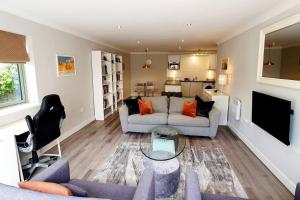 a living room with a couch and a tv at Stunning Apartment overlooking Pembroke Castle in Pembroke
