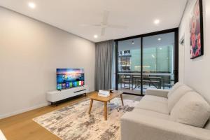 a living room with a couch and a tv at 1BR Luxury apt at prime location w carpark in Brisbane