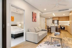 salon z kanapą i łóżkiem w obiekcie 1BR Luxury apt at prime location w carpark w mieście Brisbane